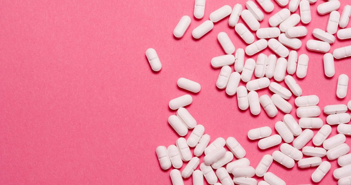 White pills on a bright pink background.